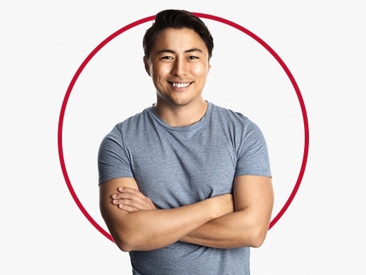 Smiling young man standing confidently and wearing grey T-shirt, happy after Canesten nail fungus treatment